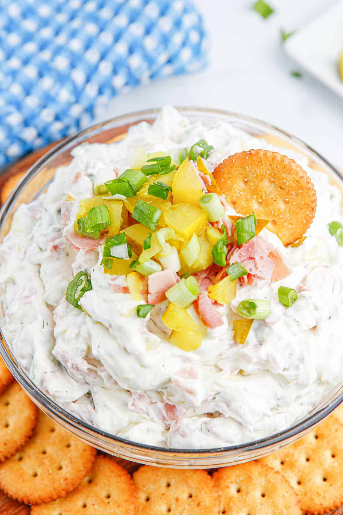 A bowl of dill pickle dip with a cracker in it.