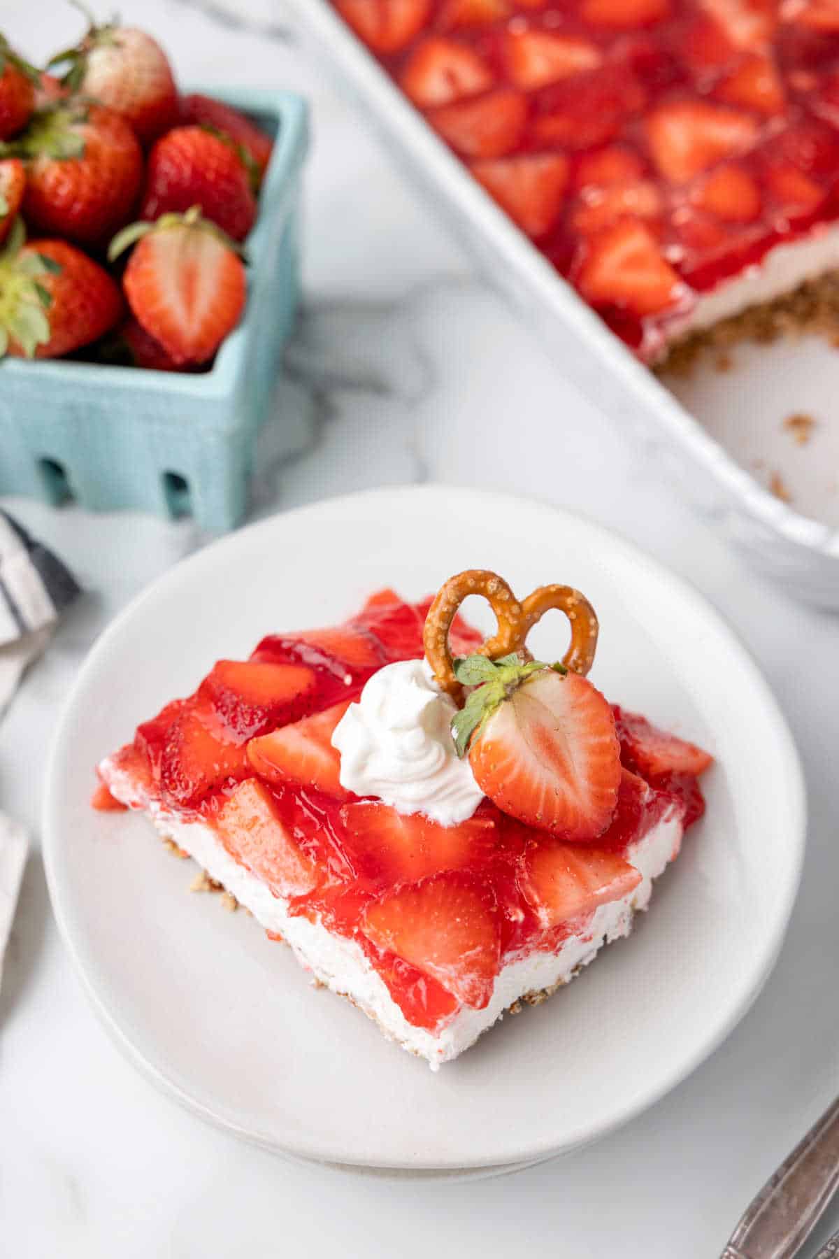 A slice of strawberry pretzel salad on a plate.