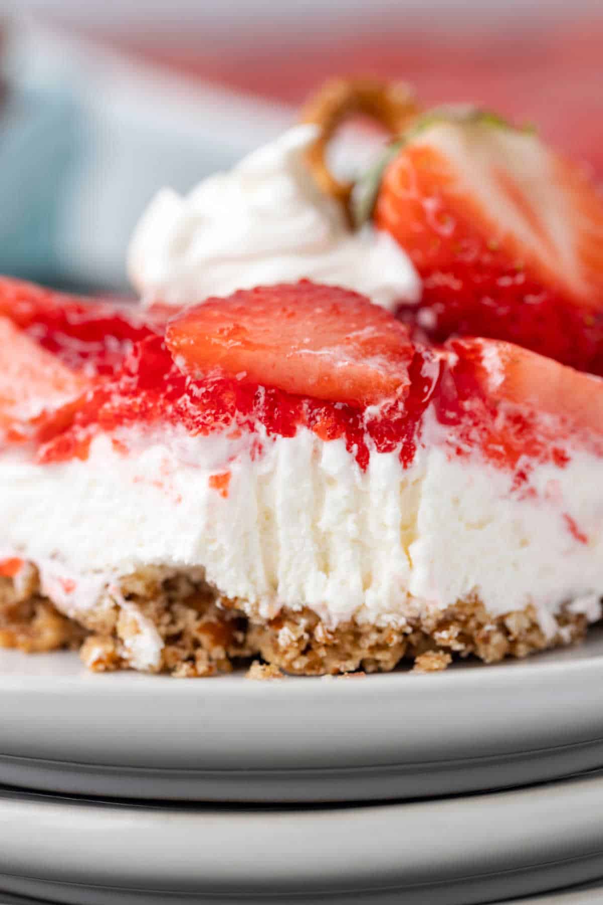 A piece of strawberry pretzel salad with a bite out of it.