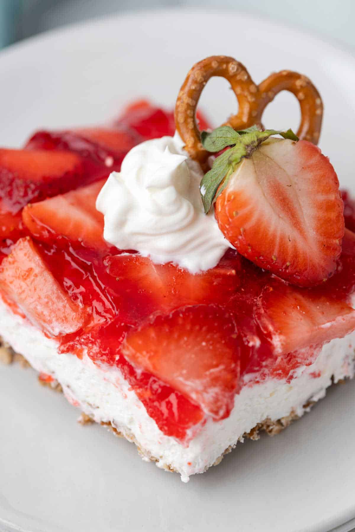 A piece of strawberry pretzel salad on a plate.