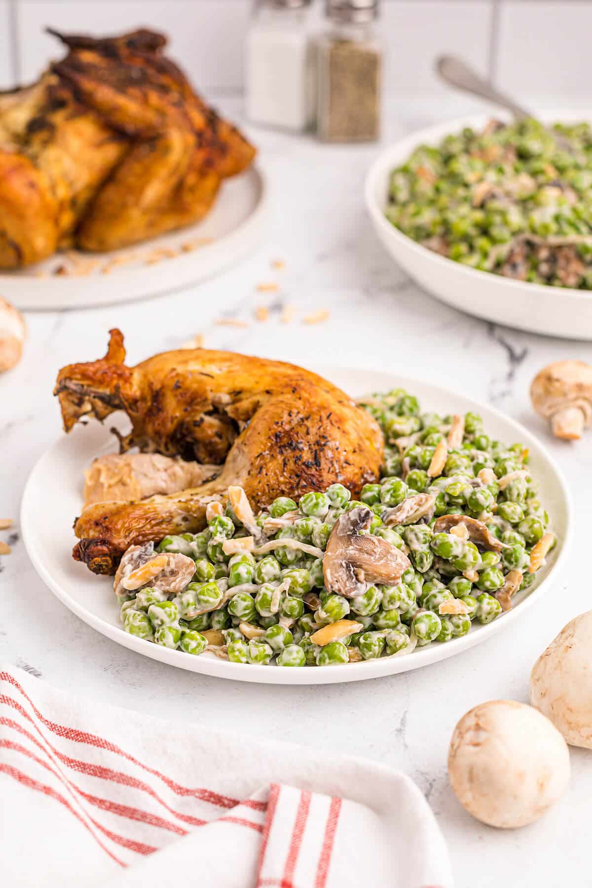 Company peas on a plate with chicken.