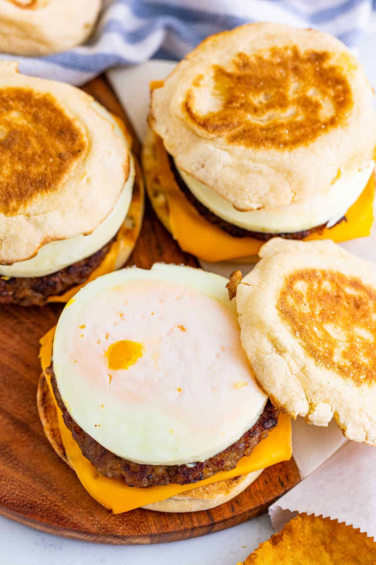 A group of breakfast sandwiches on a wooden surface.