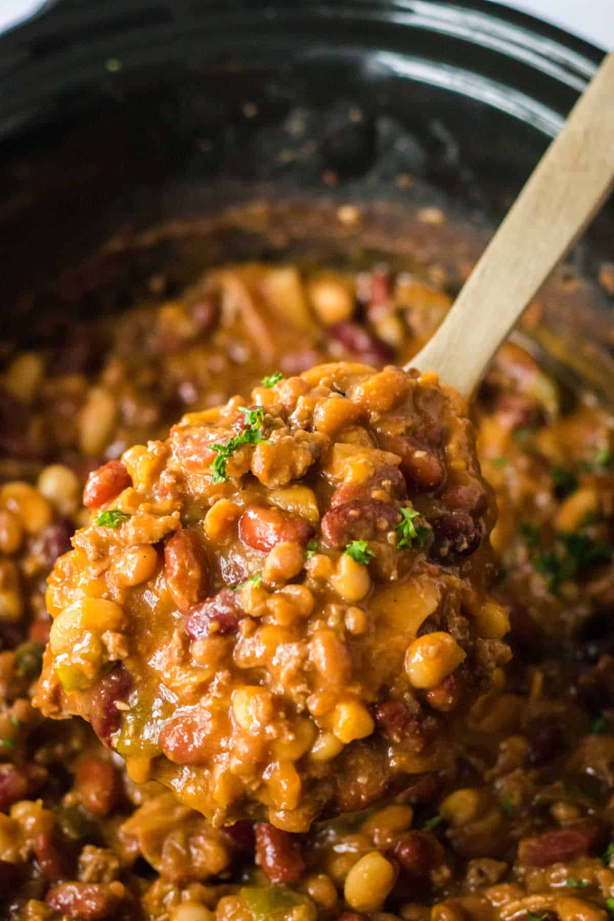 Cowboy beans on a wooden spoon.