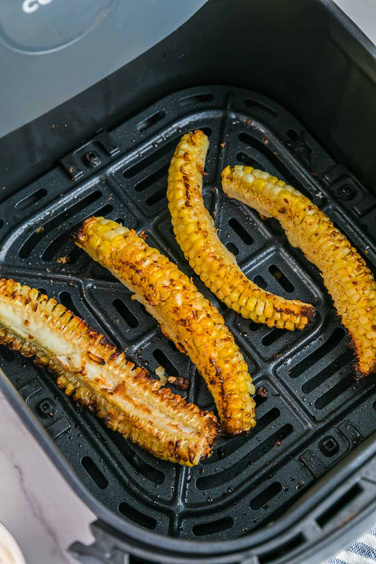 Corn ribs in an air fryer basket.