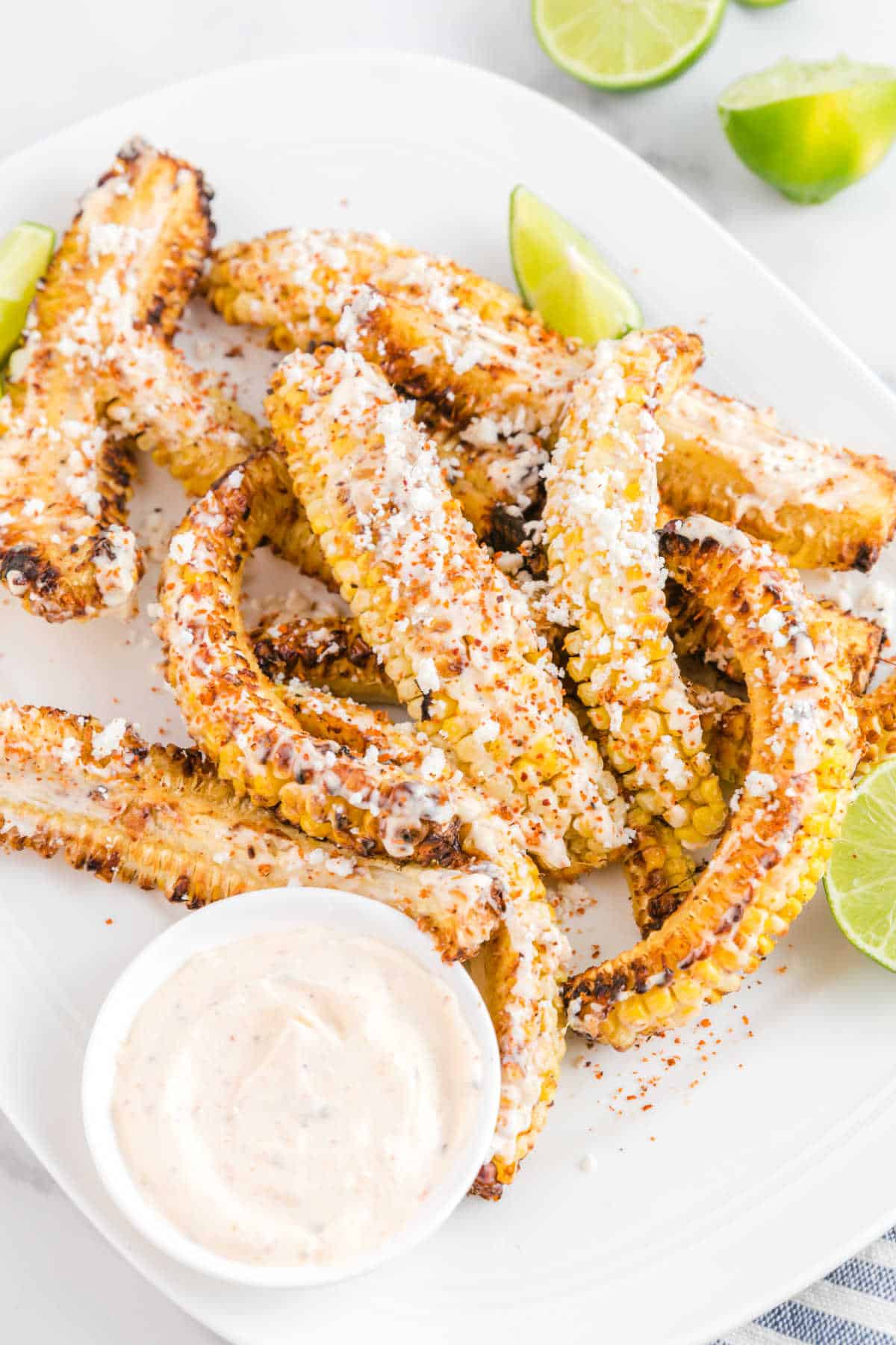 Air fryer corn ribs on a platter with dipping sauce.