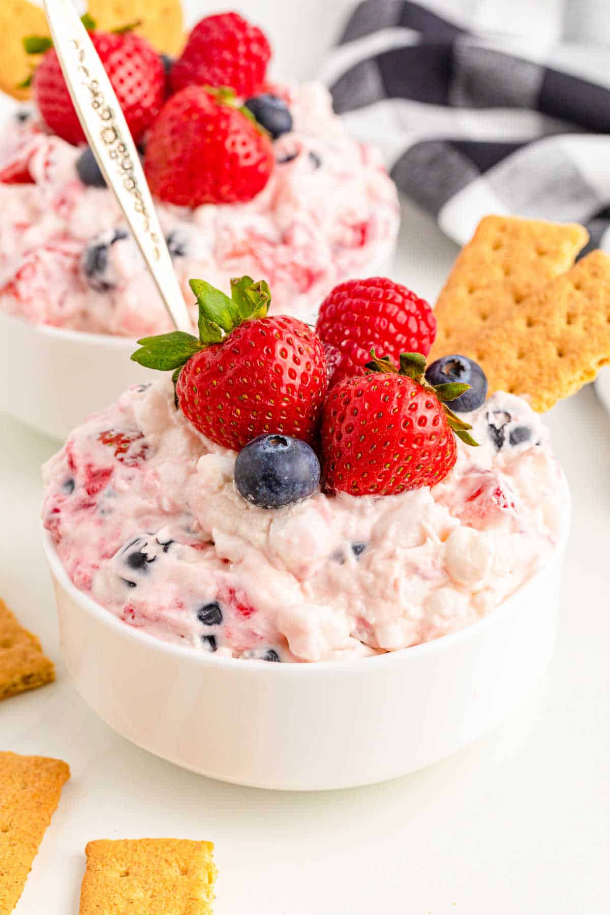 A bowl of berry cheesecake fluff with a spoon.