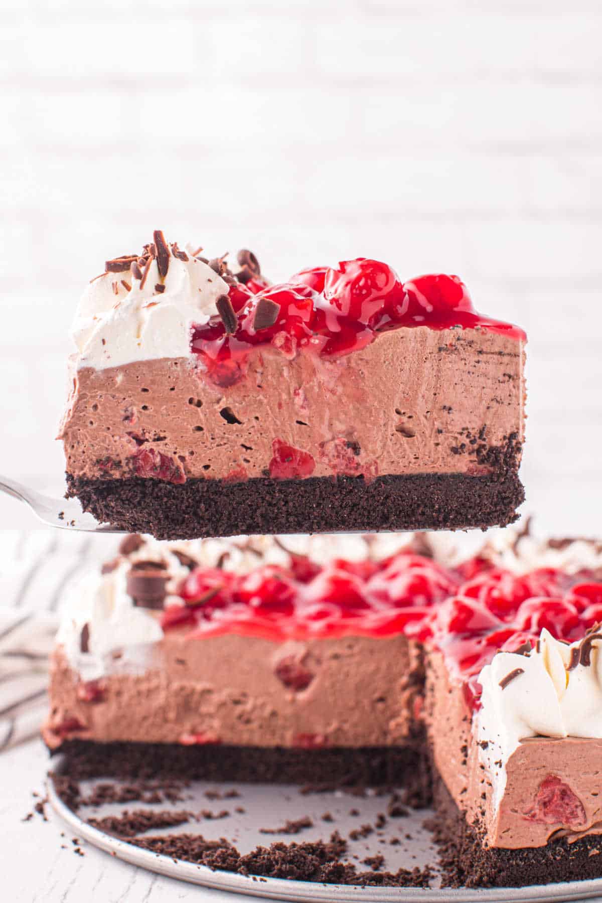 A slice of black forest cheesecake on a serving spatula.