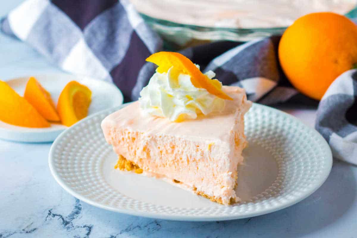 A slice of orange creamsicle pie on a plate.