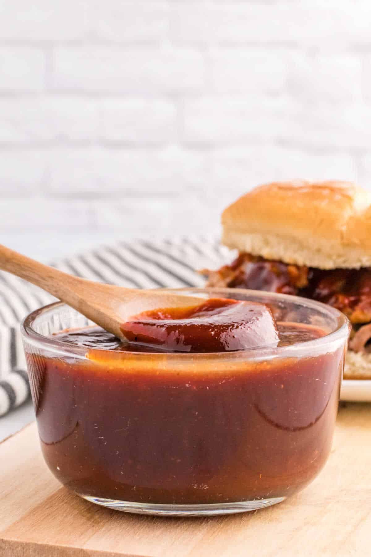 A bowl of homemade bbq sauce with a wooden spoon.