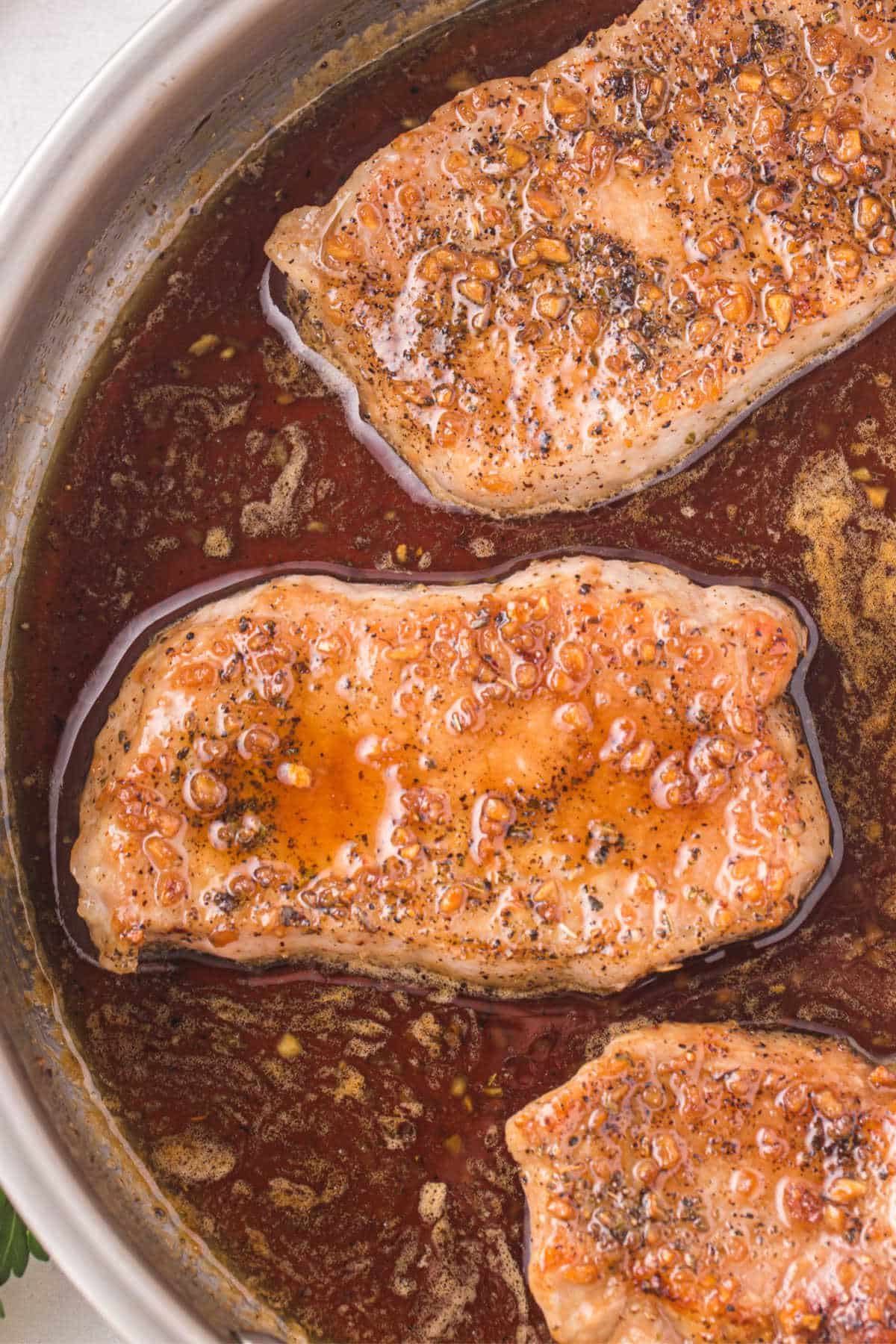 Honey garlic pork chops in a pan.