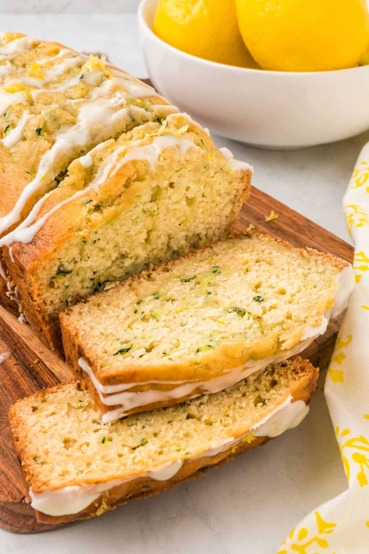 A loaf of lemon zucchini bread with slices cut.