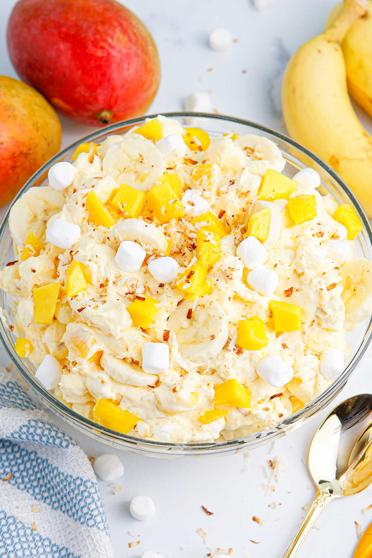 A bowl of mango banana marshmallow salad.