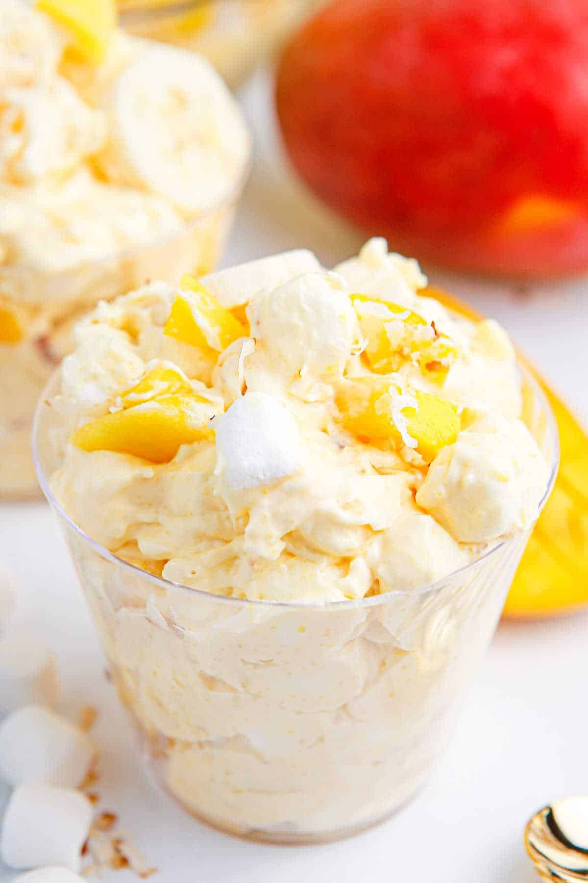 Mango banana marshmallow salad in a parfait dish.