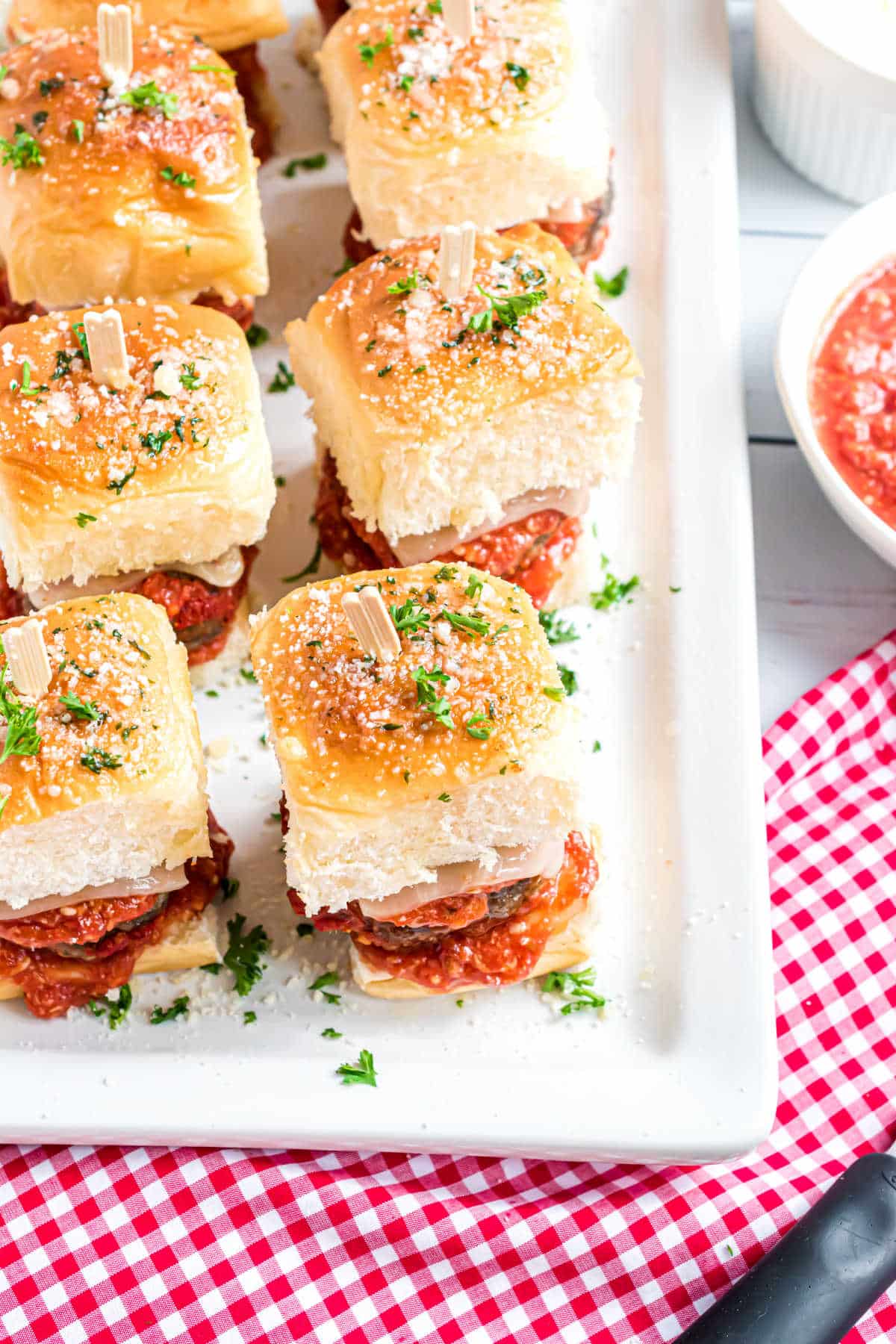 Meatball sliders on a platter with toothpicks through the top.