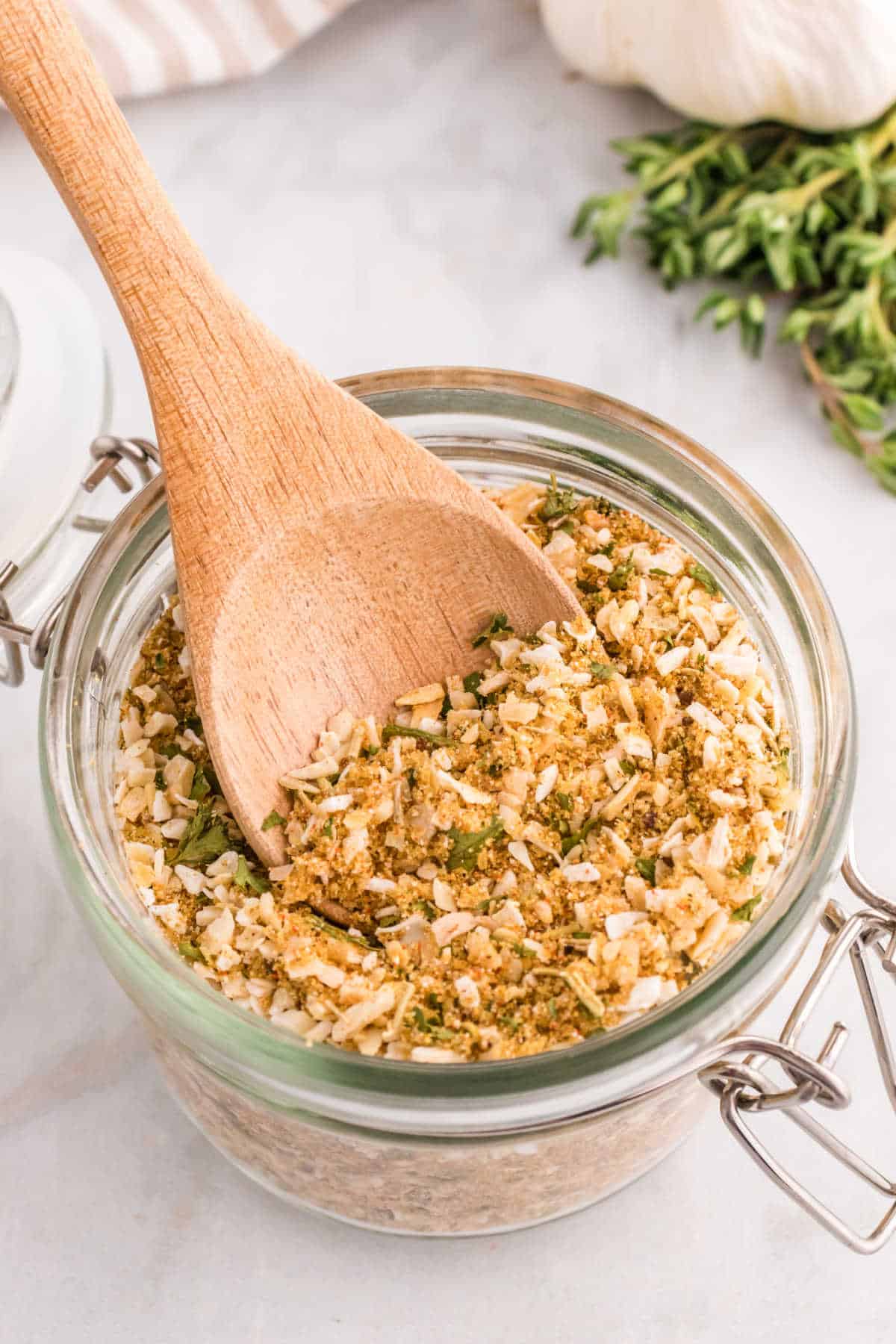 Onion soup mix in a jar with a wooden spoon.