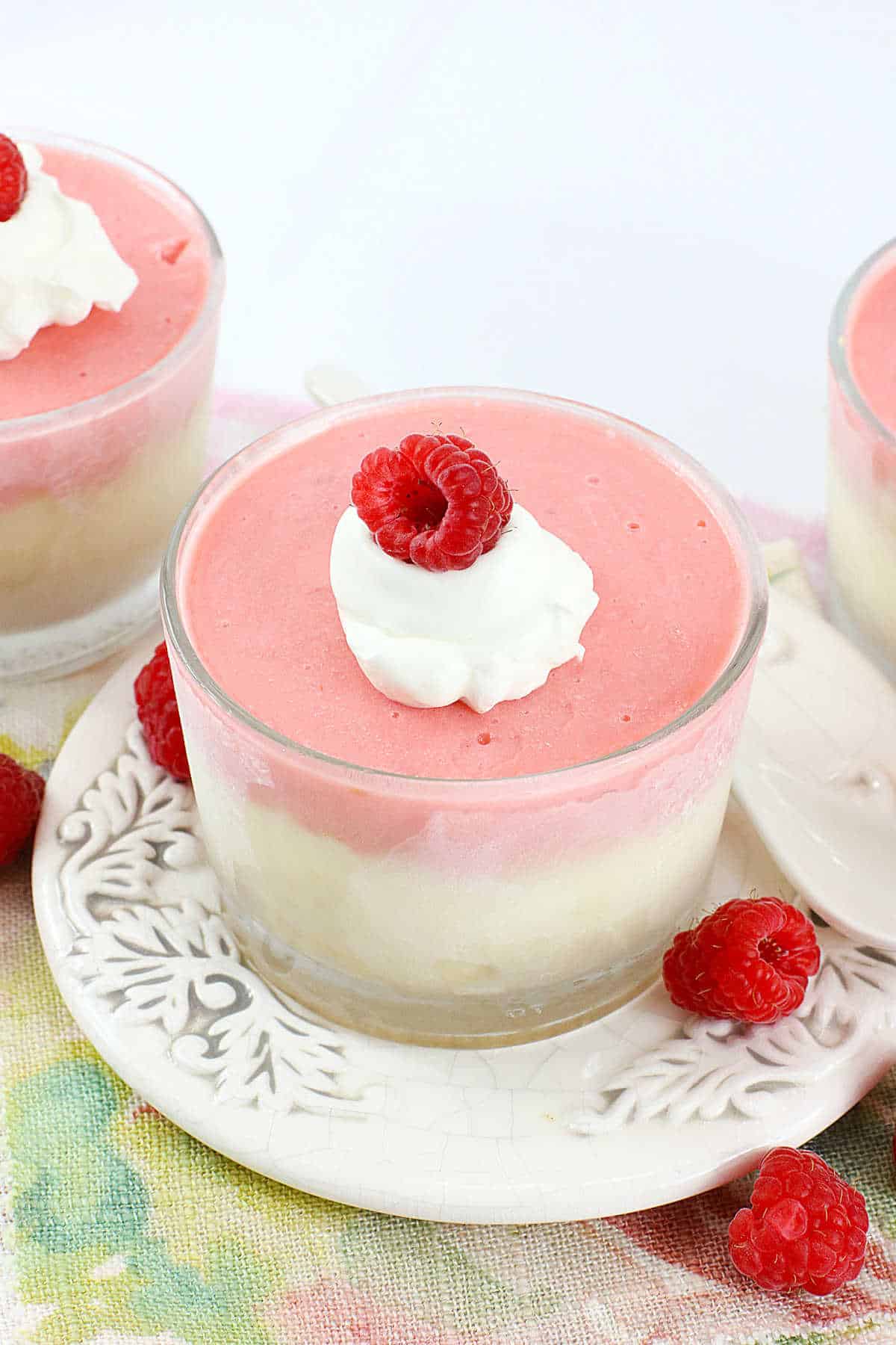 Raspberry cheesecake cups on a plate.