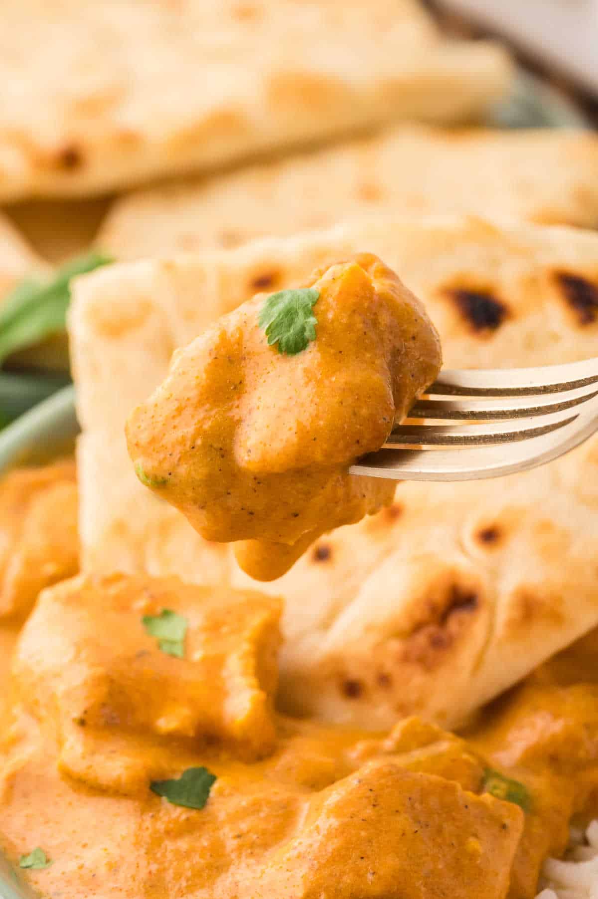 Butter chicken on a fork.