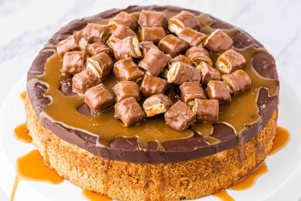 Twix Cheesecake on a white marble surface.