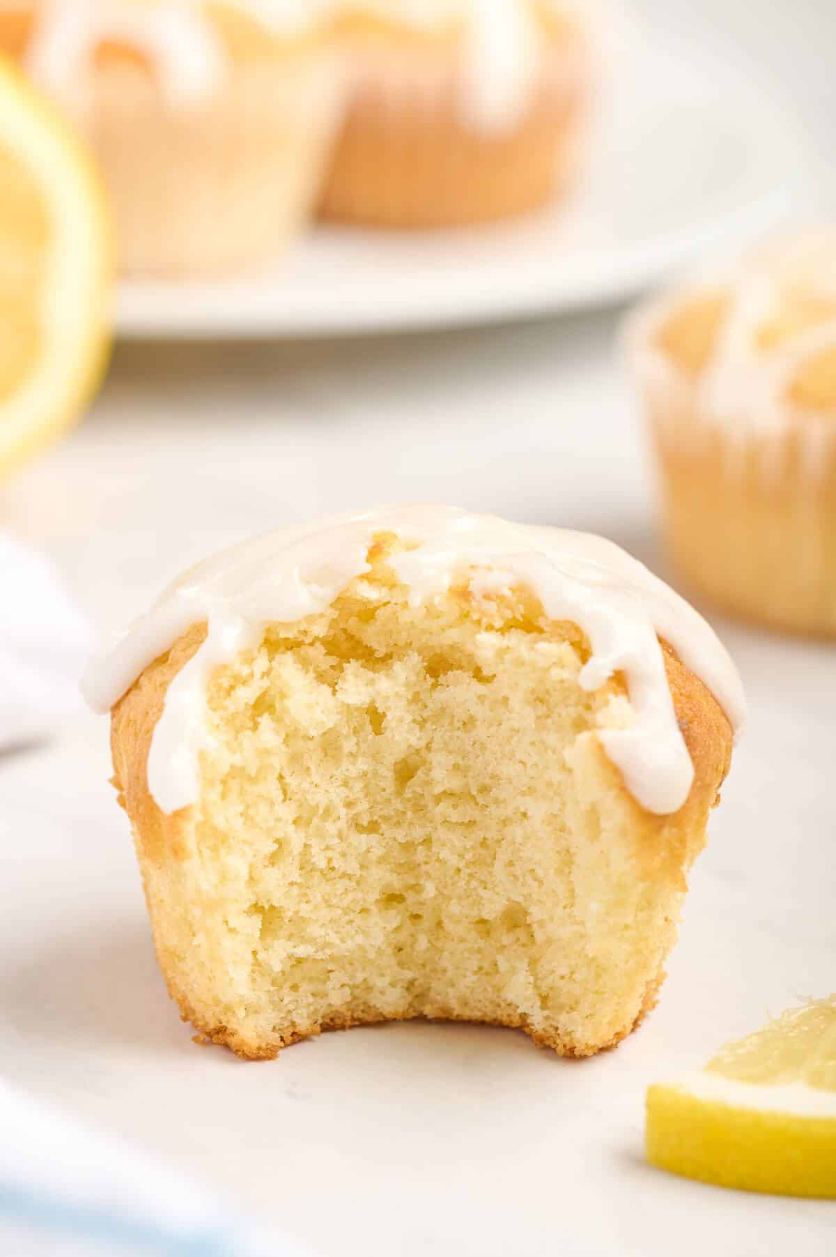 A lemon pound cake muffin with a bite out of it.