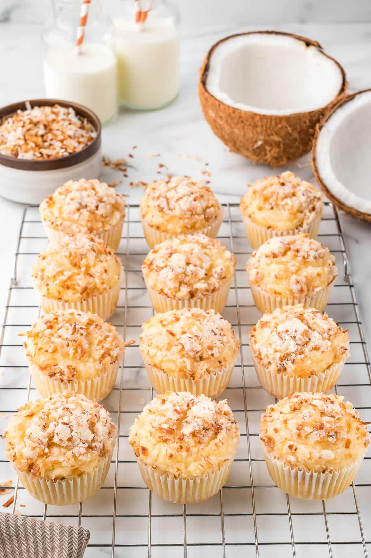 Toasted coconut muffins on a wire rack.