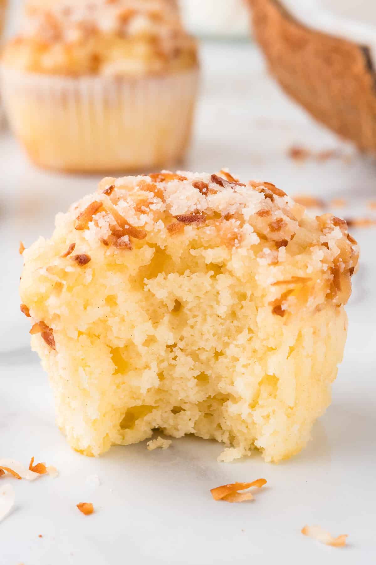 A bite out of a toasted coconut muffins.