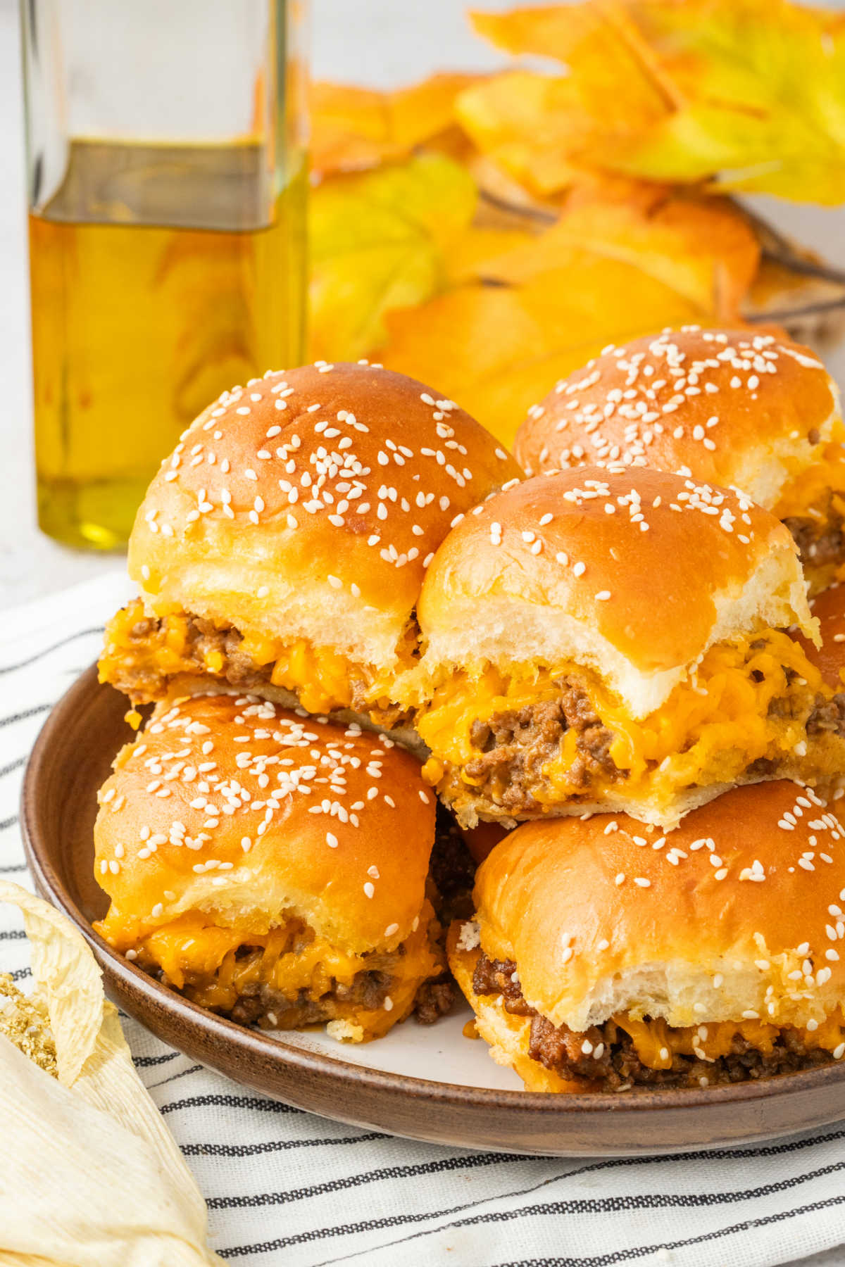 A pile of cheeseburger sliders on a plate.