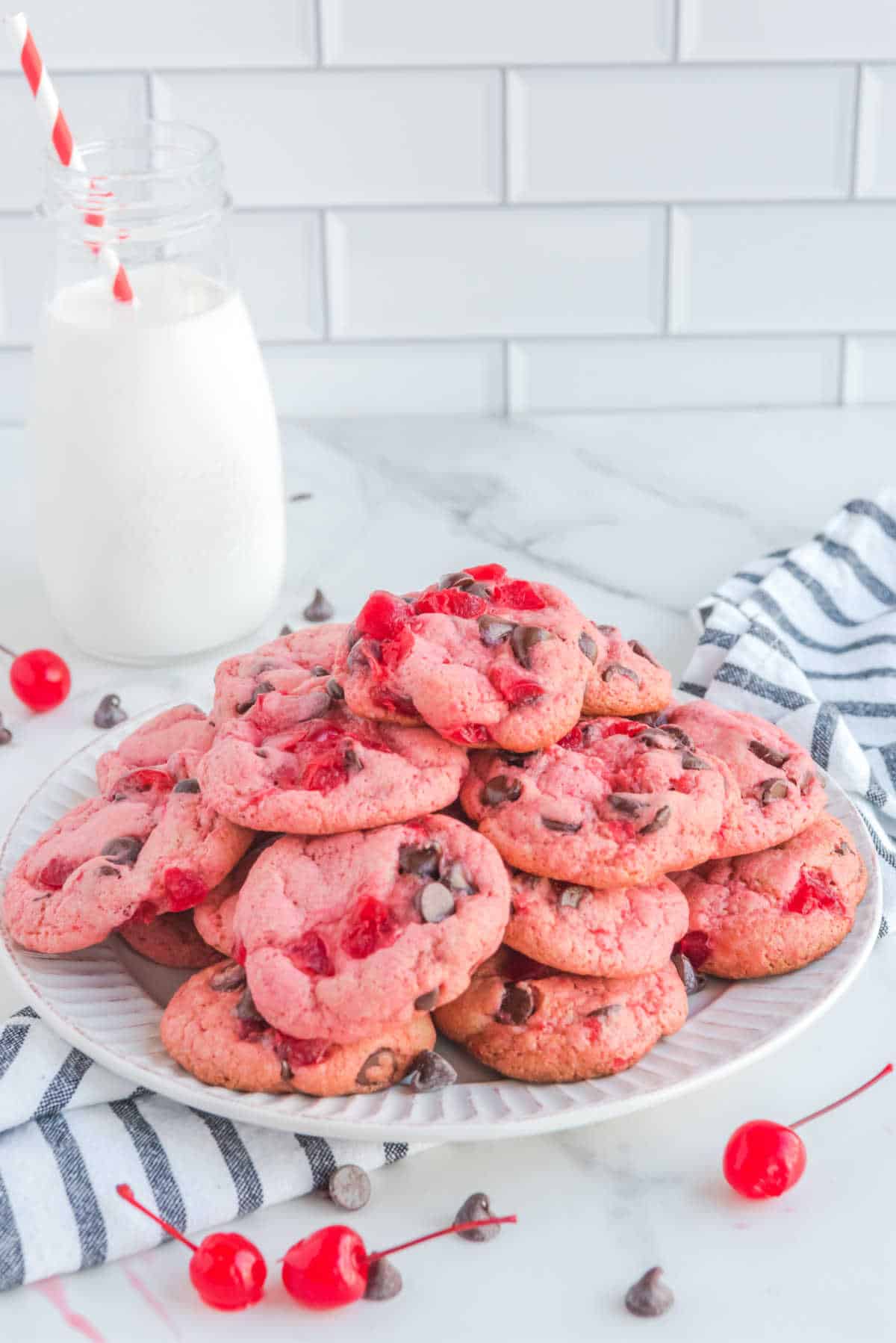 A pile of cherry cookies on a plate.