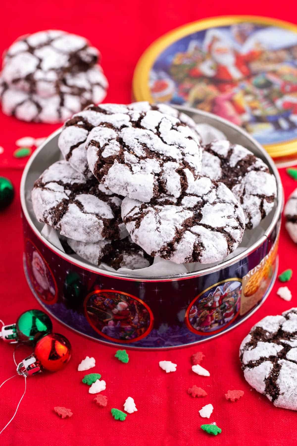 Chocolate crinkle cookies in a holiday tin.