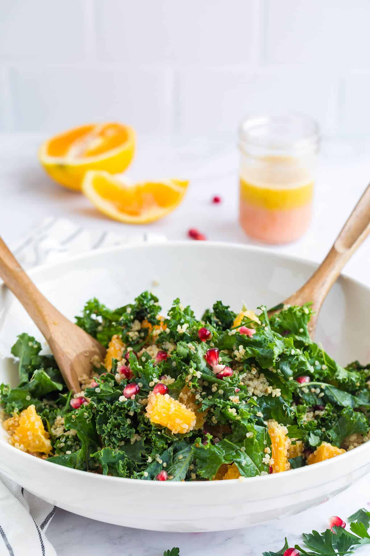 A bowl of winter detox salad with salad tongs.