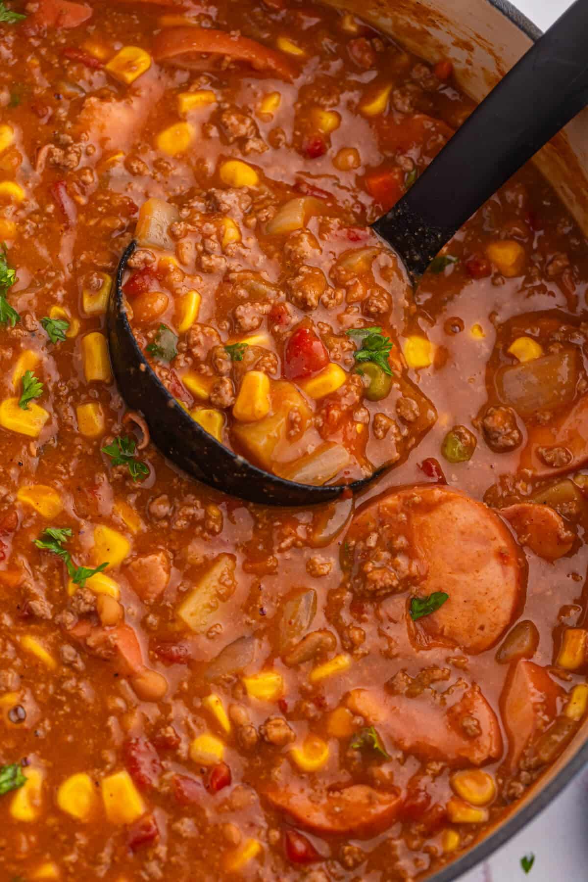 Cowboy stew in a pot with a ladle.