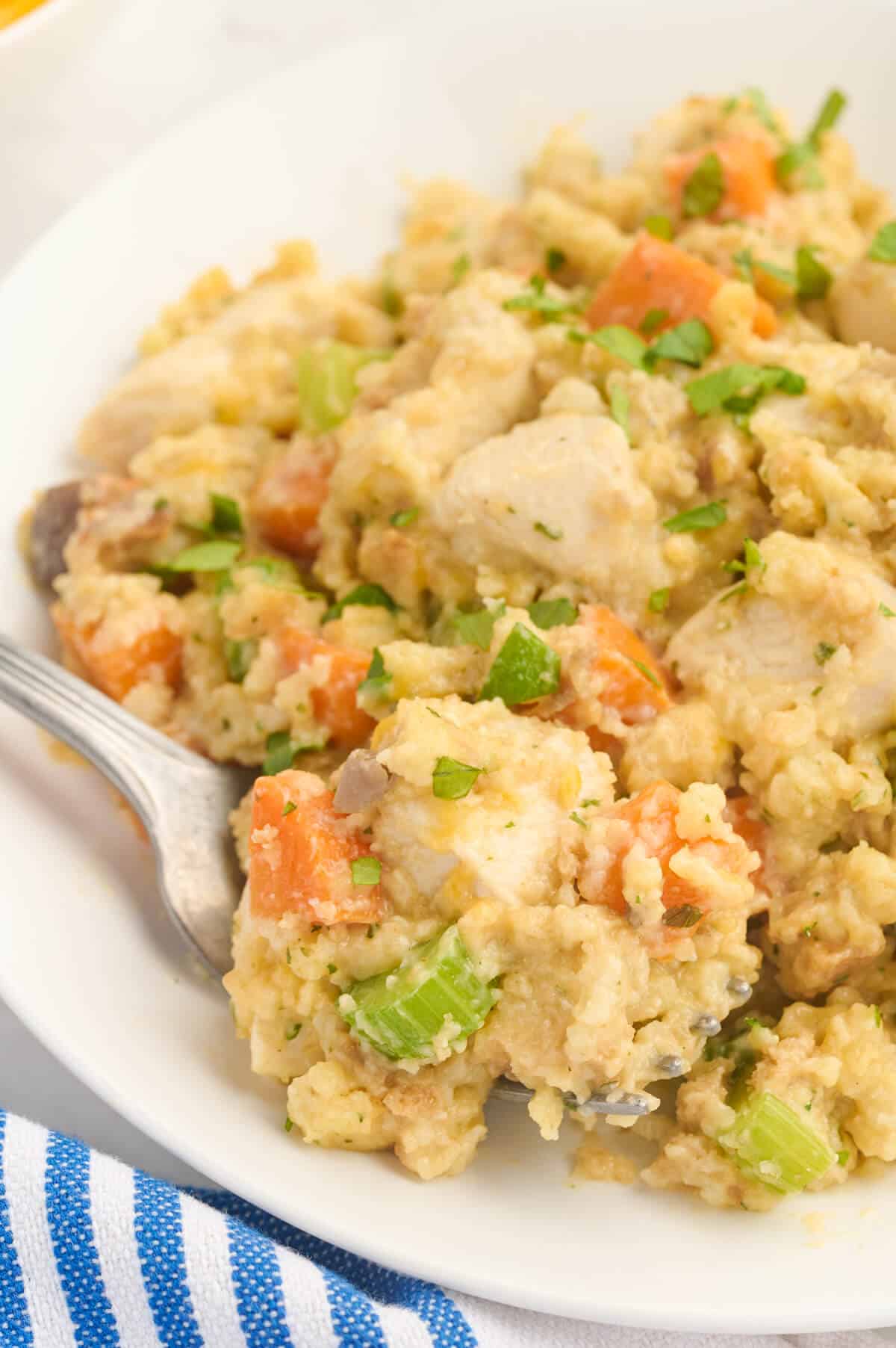 A plate of chicken and stuffing with a fork.