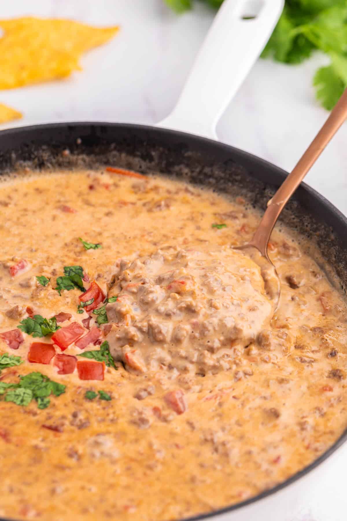 A spoon in a skillet of Rotel Dip.