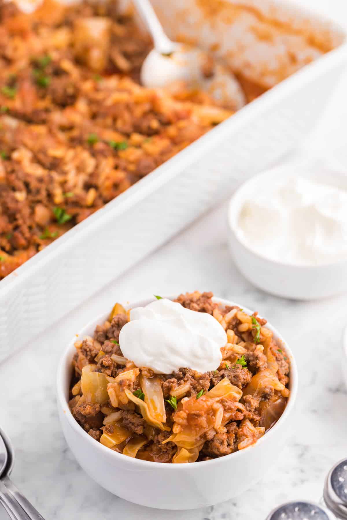 Cabbage roll casserole in a bowl topped with sour cream.