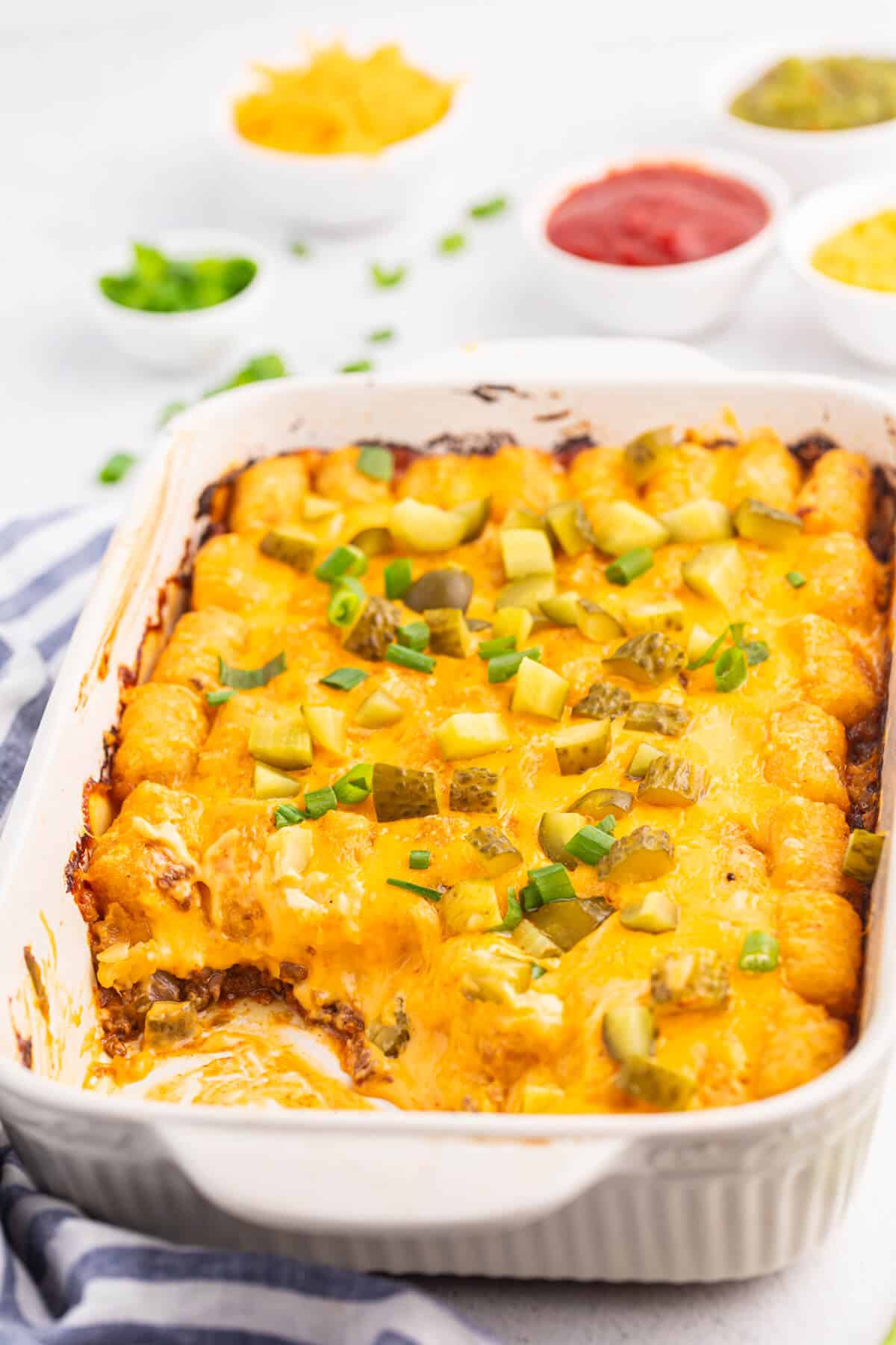 A scoop of cheeseburger tater tot casserole out of a pan.