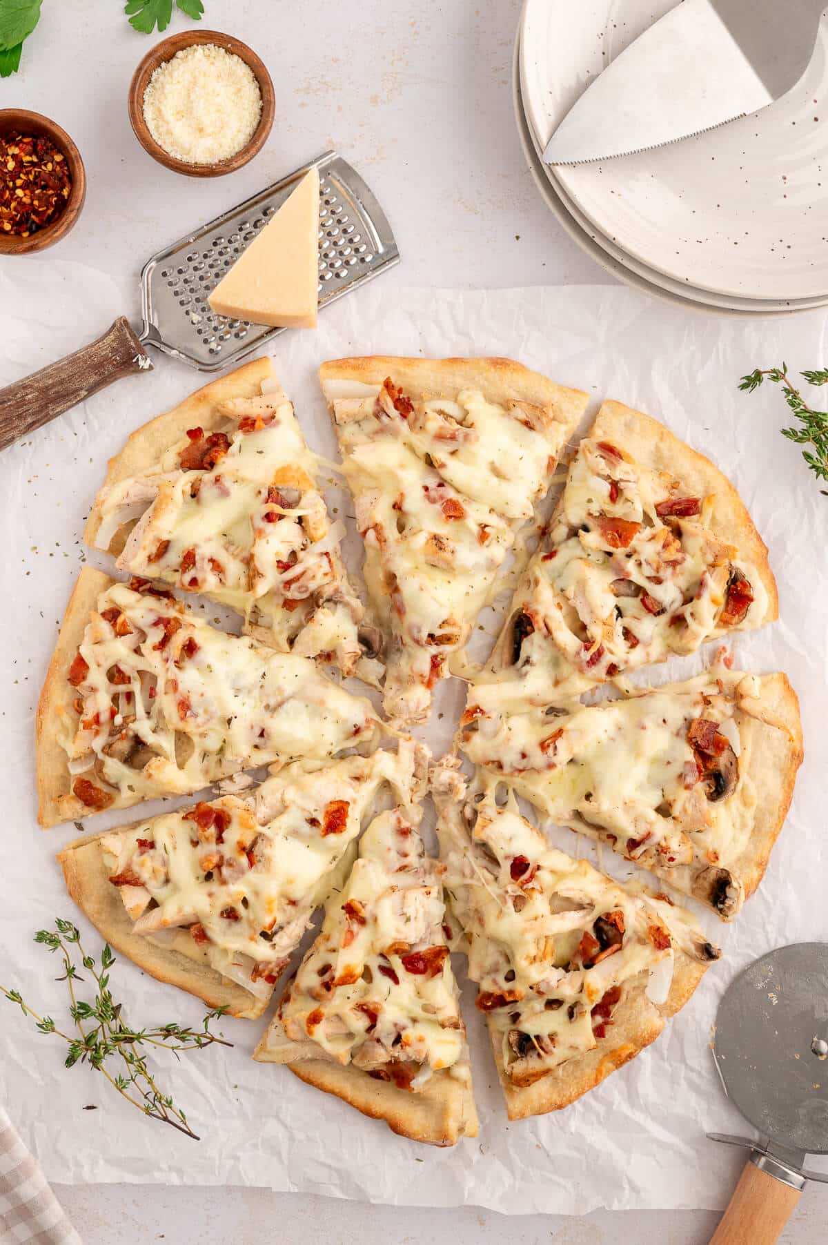 Chicken bacon alfredo pizza cut into slices.