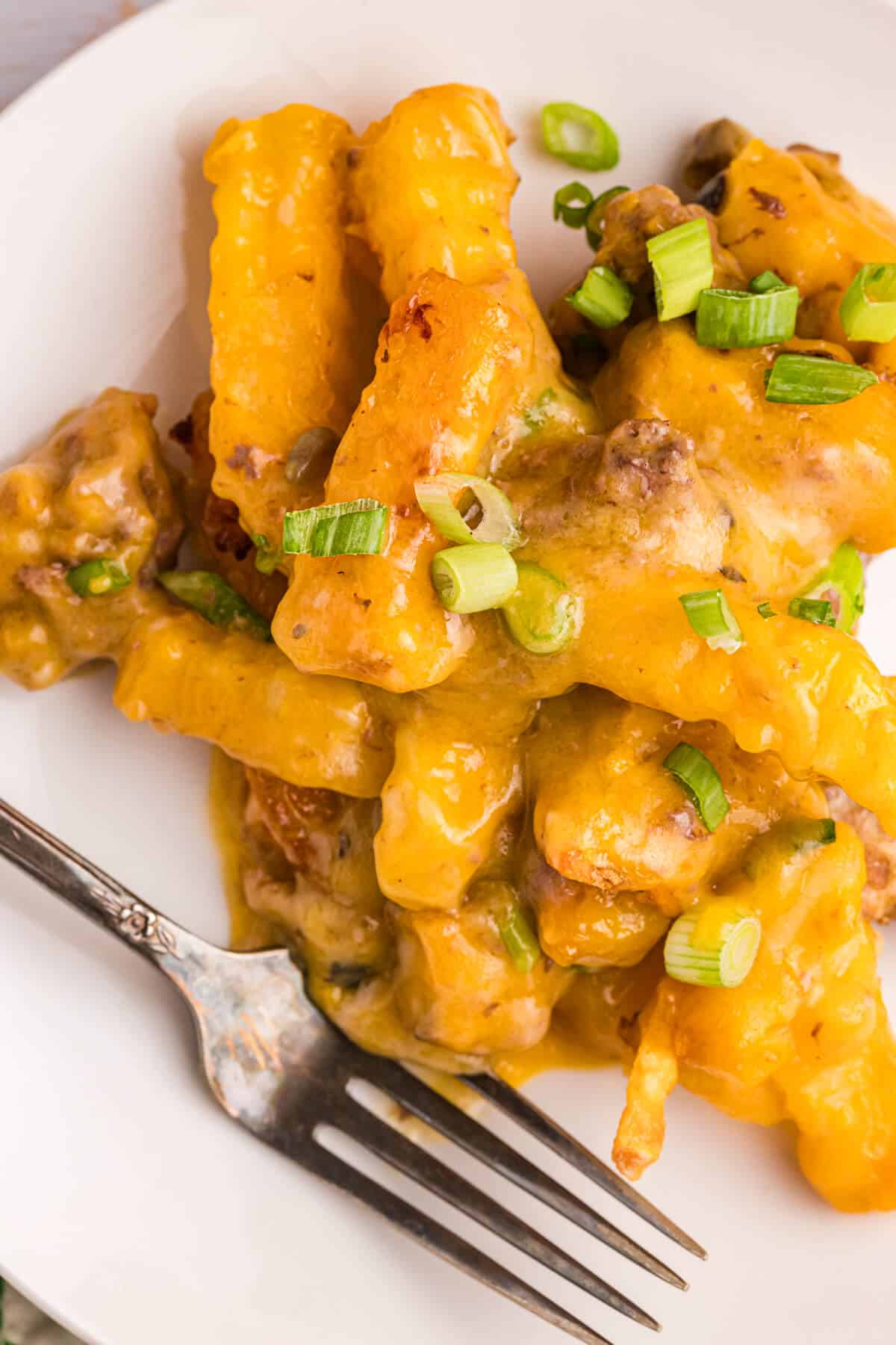 French fry casserole on a plate with a fork.