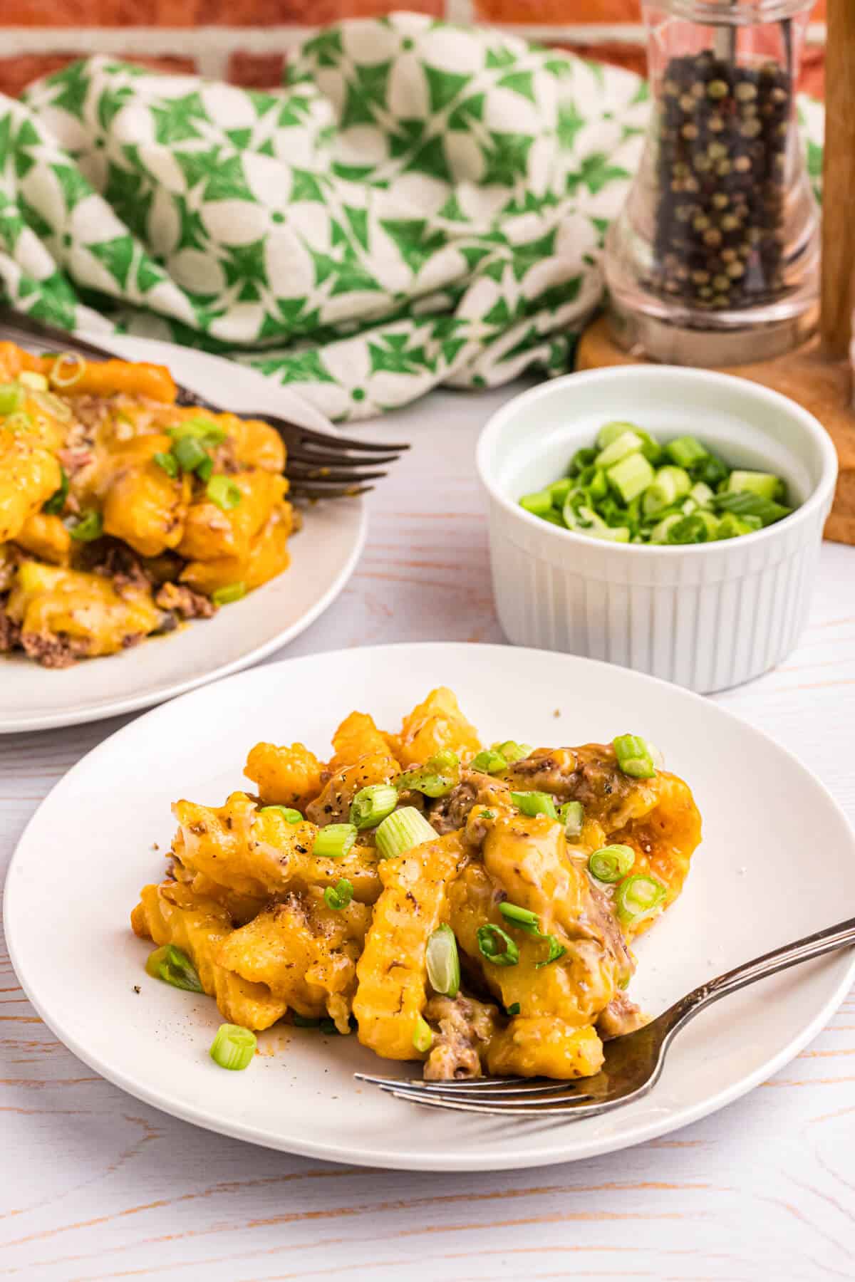 French fry casserole on a plate with a fork.