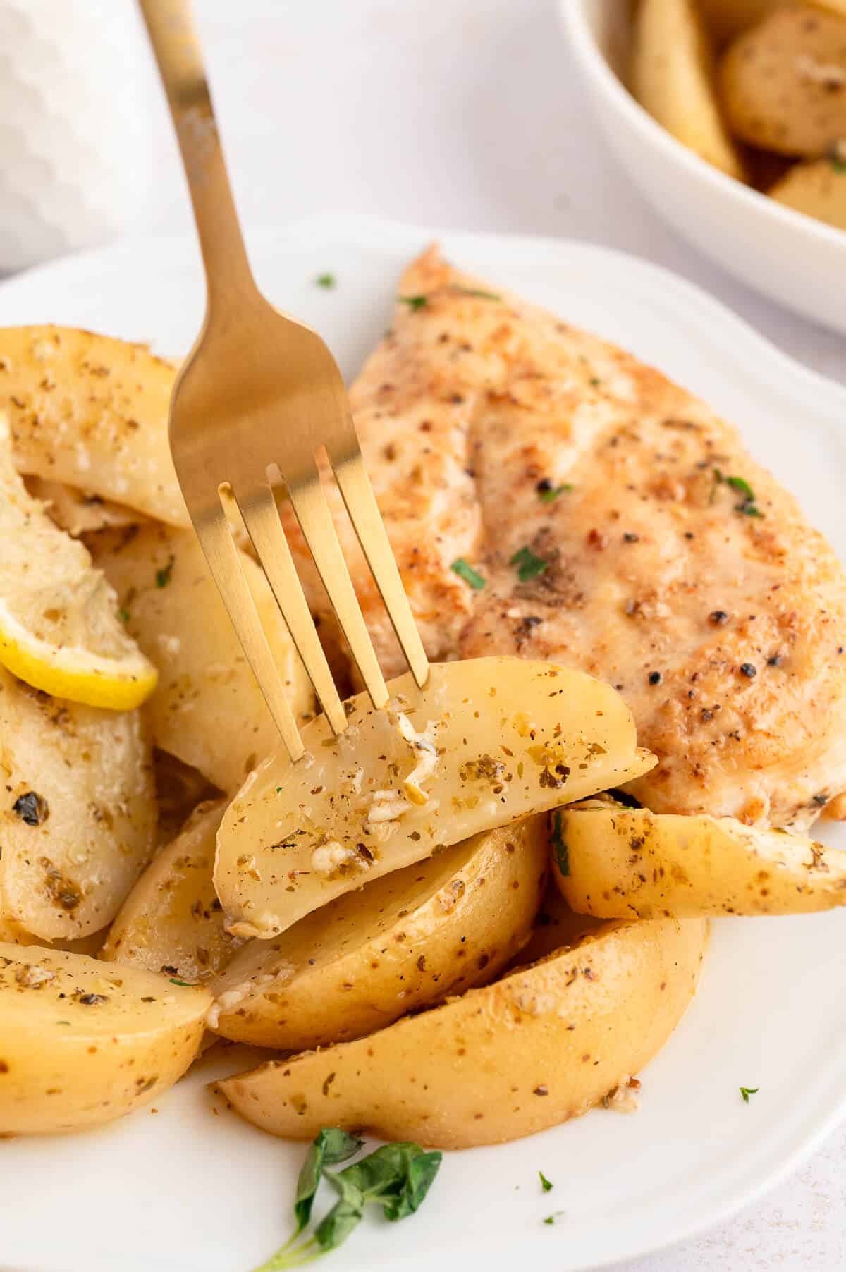 A plate of lemon roasted potatoes with a fork.