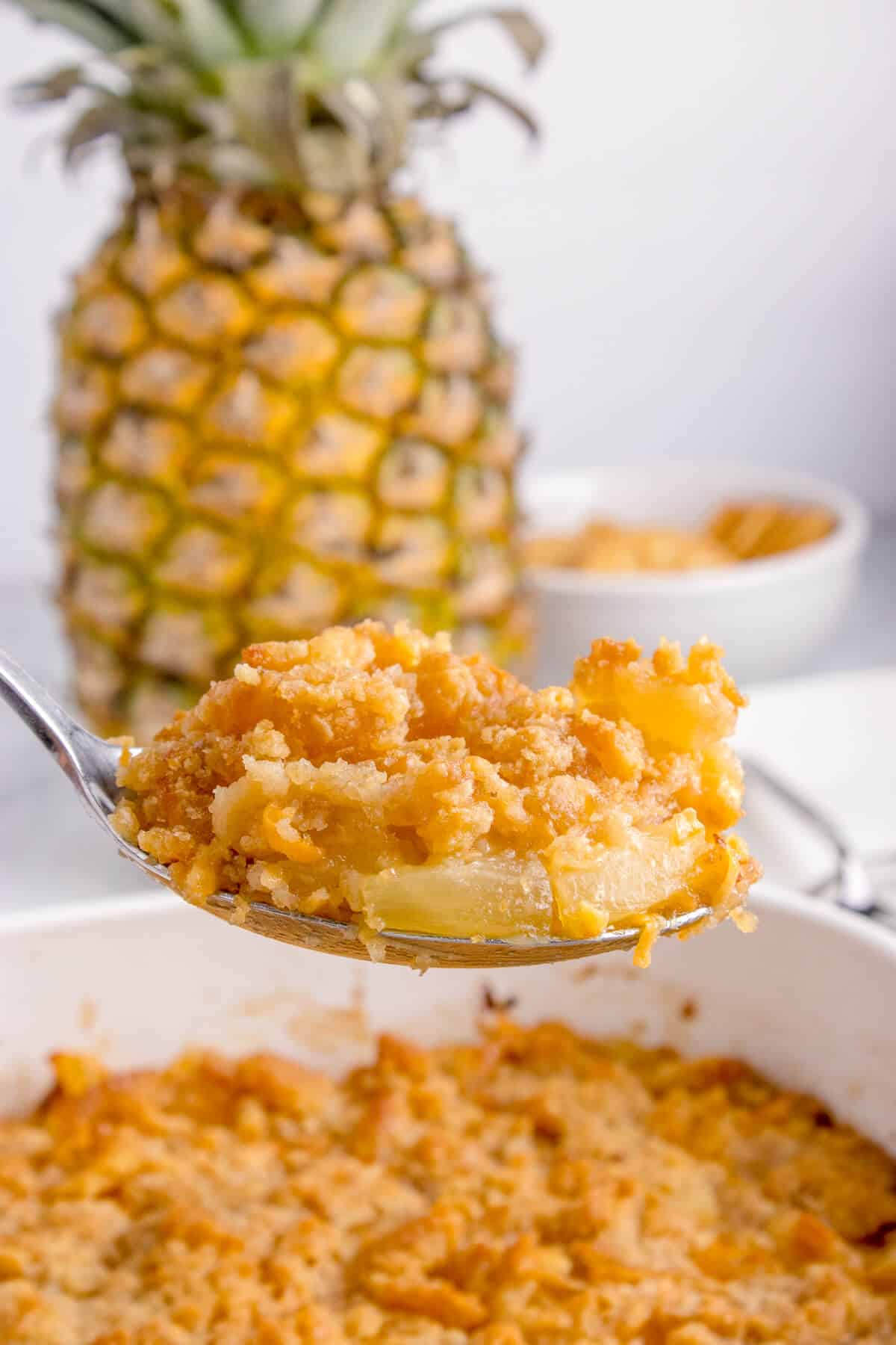 A serving spoon with pineapple casserole.