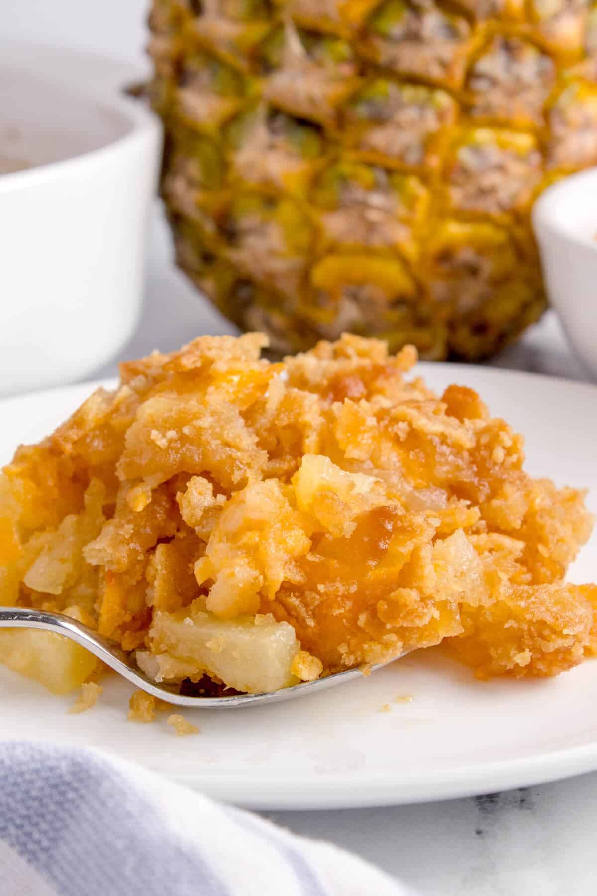 A scoop of pineapple casserole on a plate.