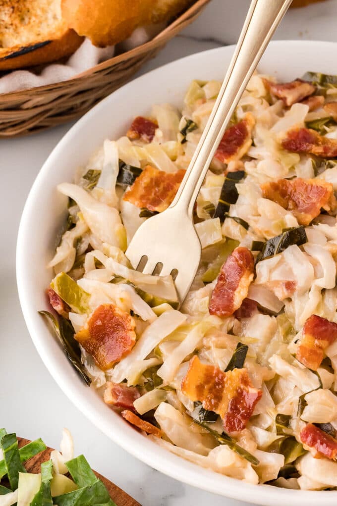 Sweet and sour cabbage in a bowl with a fork.