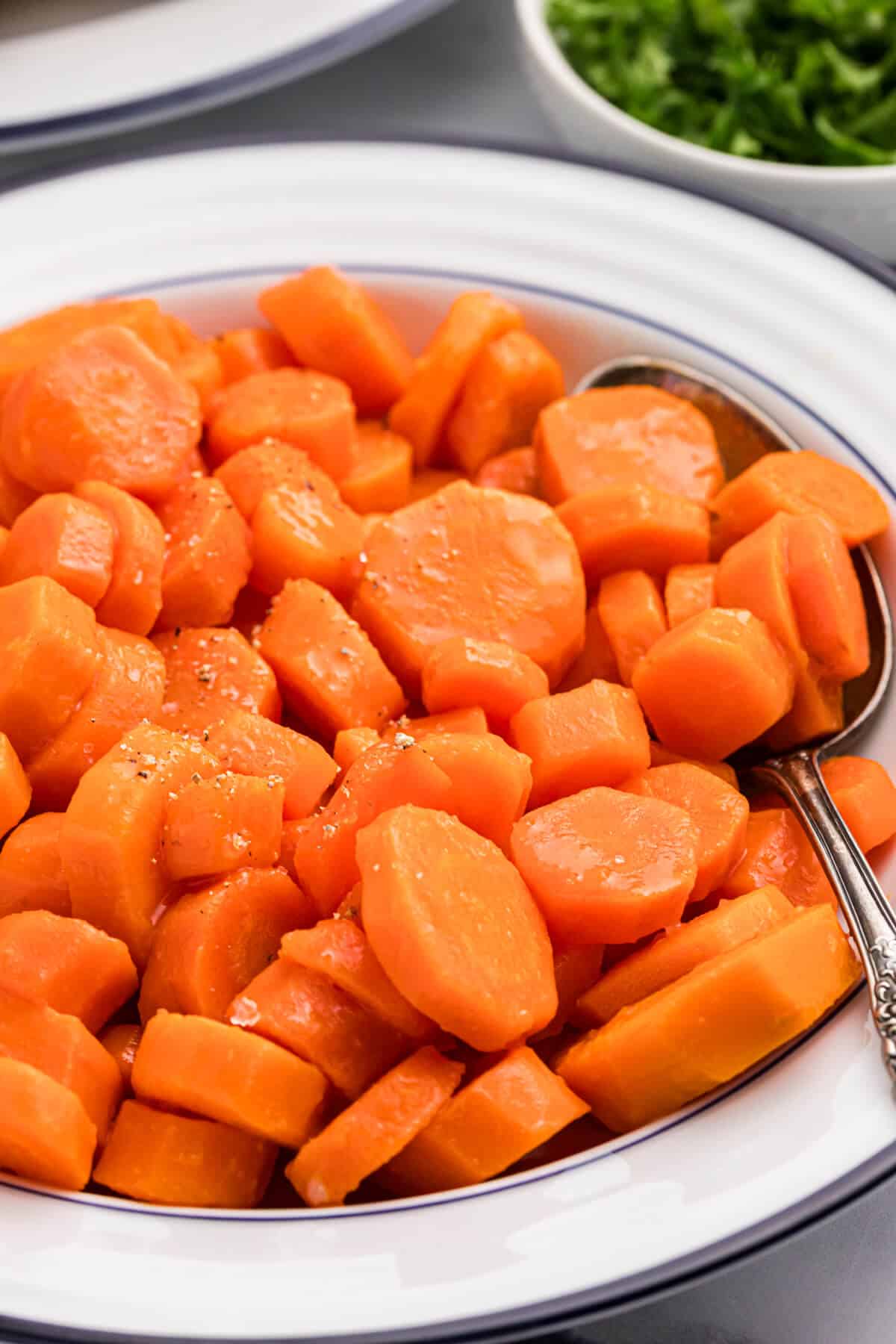 Sweet and sour carrots in a bowl with a spoon.