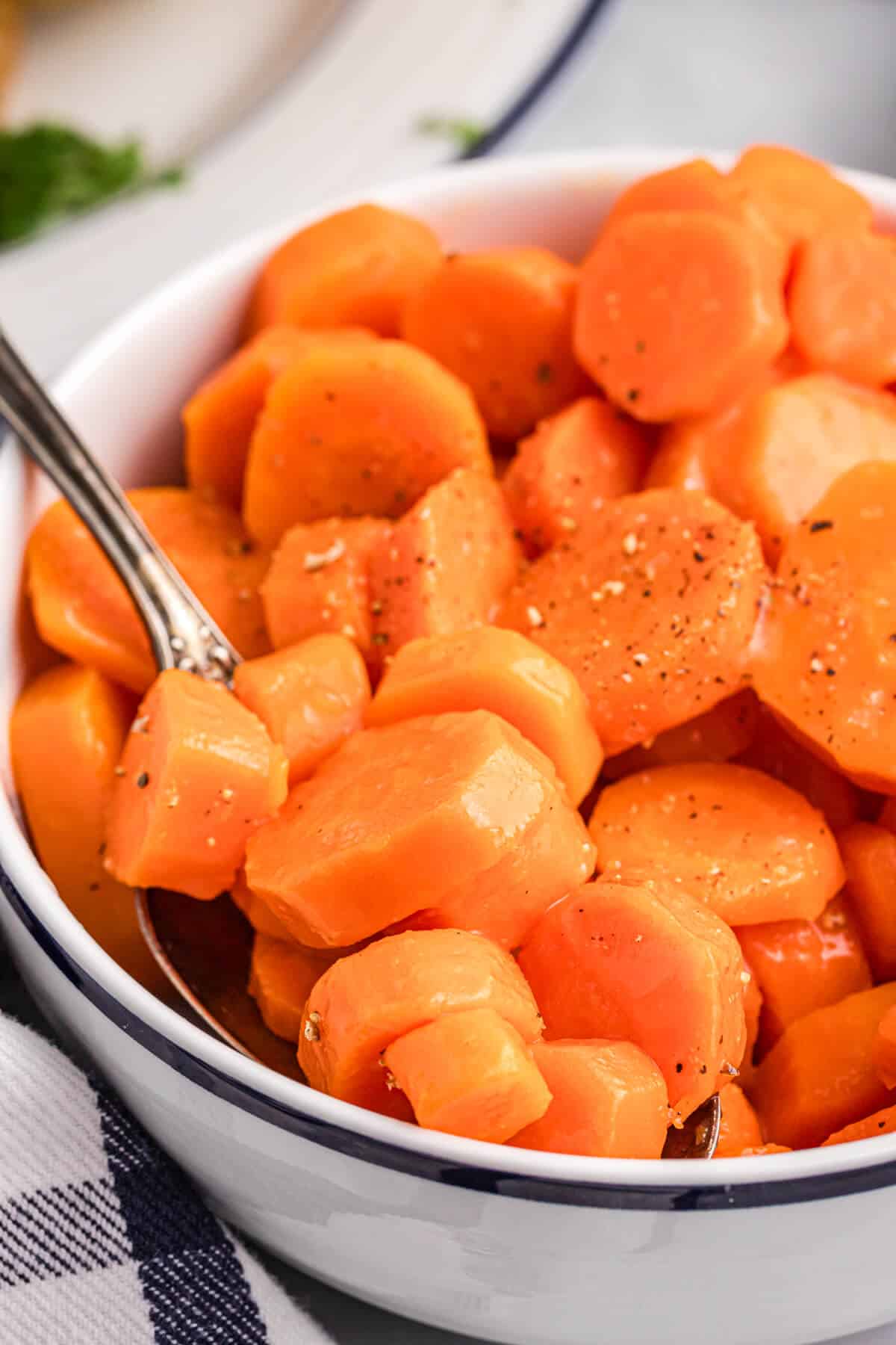 Sweet and sour carrots in a bowl with a spoon.