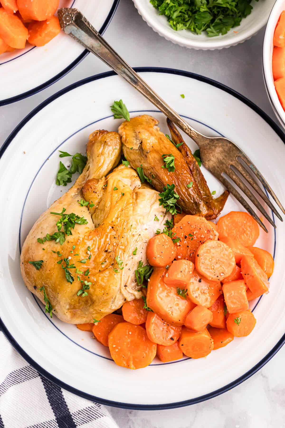 Sweet and sour carrots on a plate with chicken.