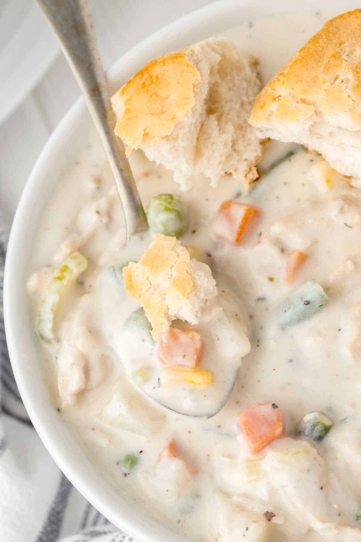 A bowl of chicken pot pie soup with a spoon.