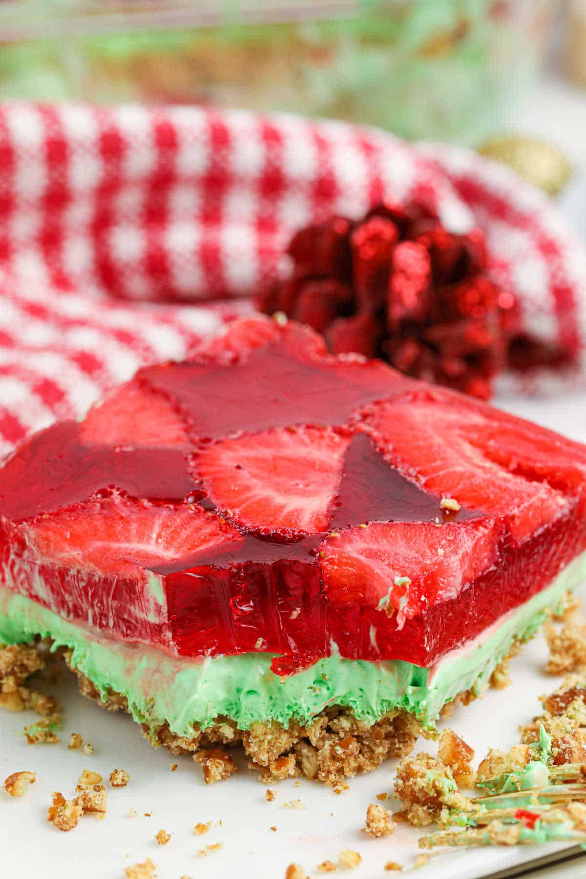 A slice of Christmas pretzel salad on a plate with a bite out of it.