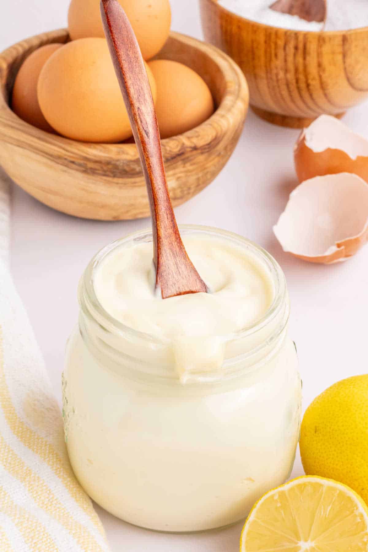 A jar of mayonnaise with a wooden spoon in it.