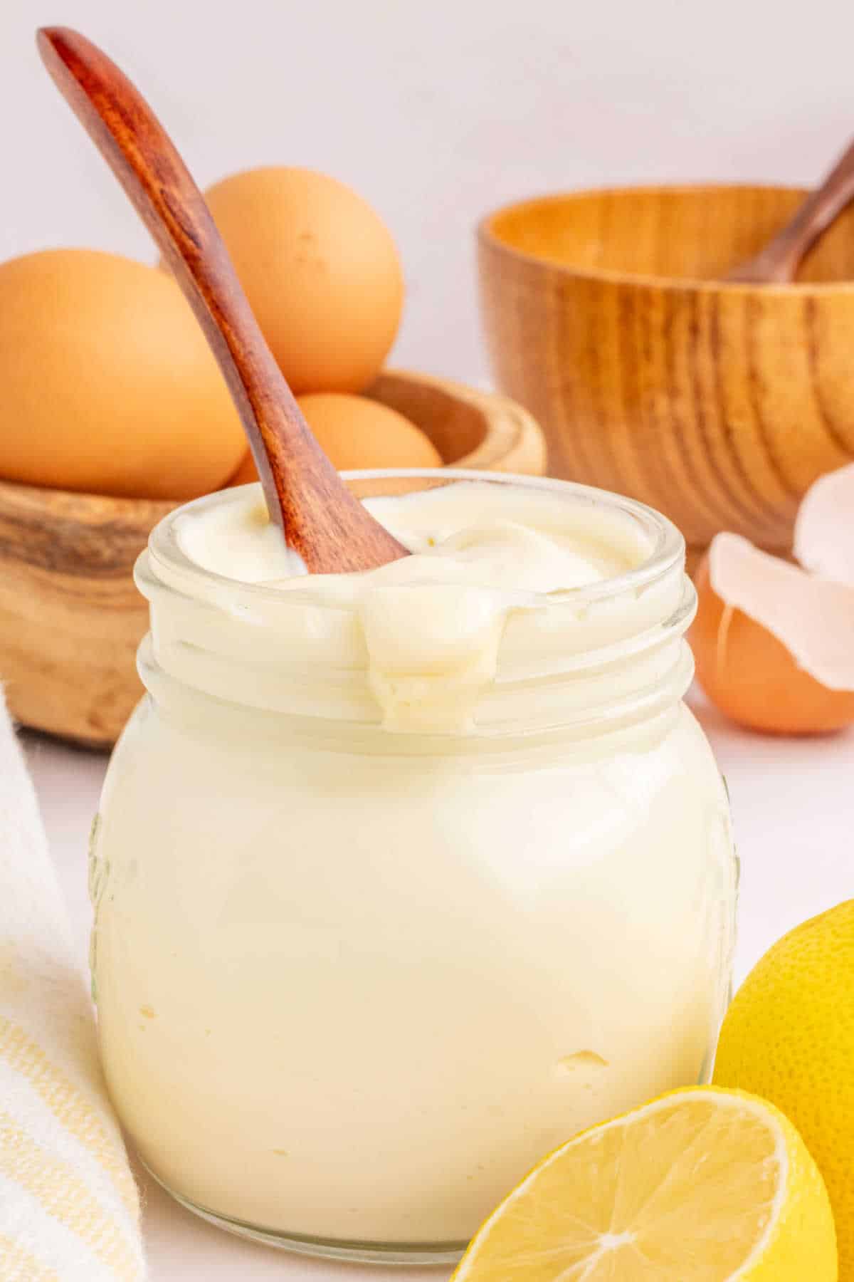 A jar of mayonnaise with a wooden spoon in it.