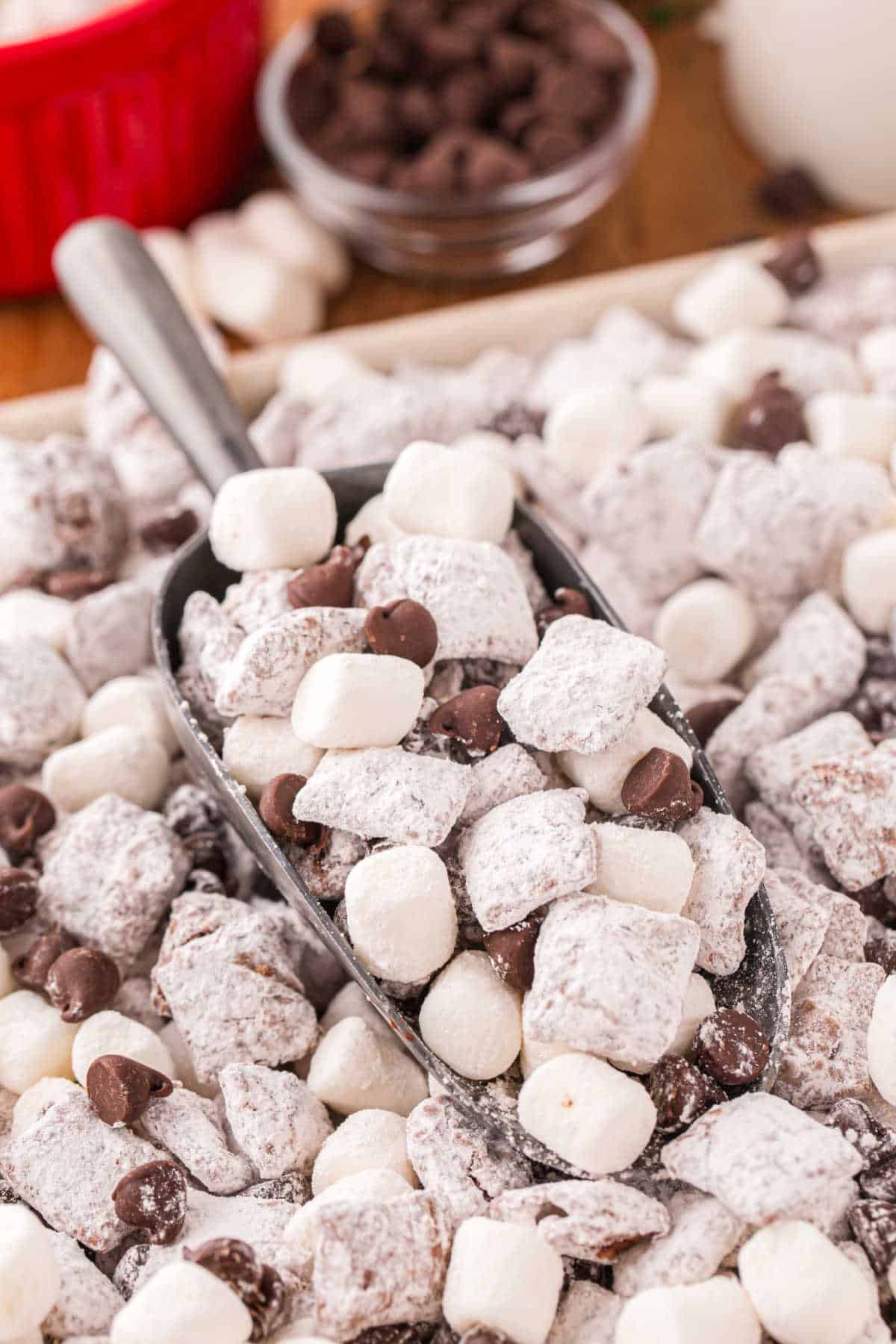 Hot chocolate muddy buddies on a serving scoop.