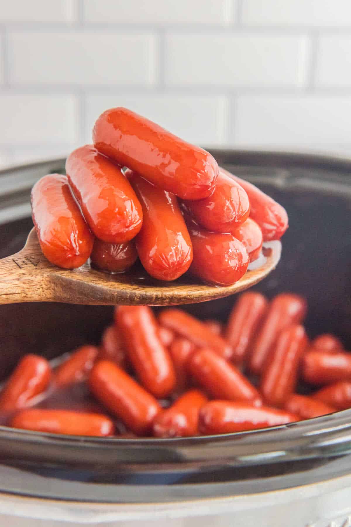 Little smokies on a wooden spoon.